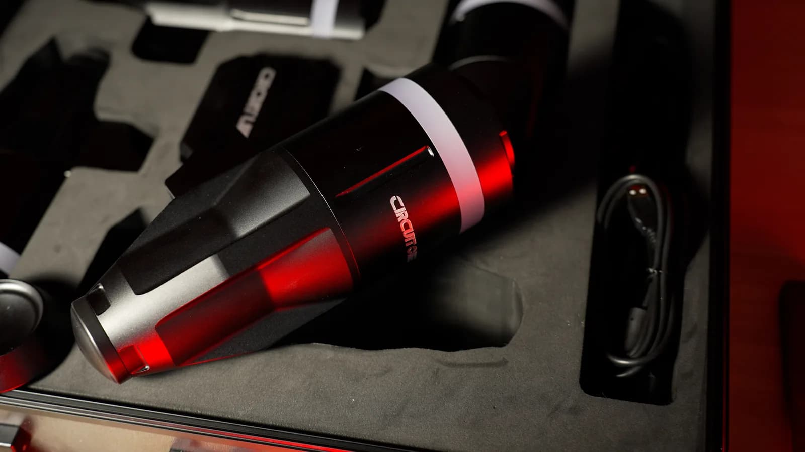 A D Force 1 actuator lying in the foam of its case under red light